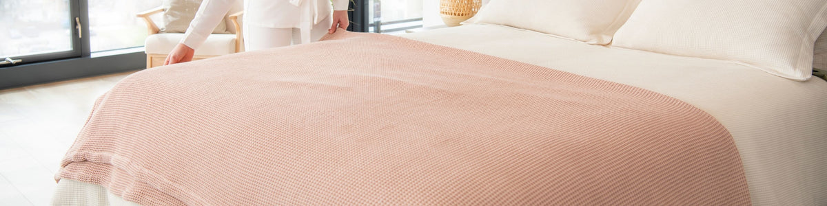 A pink waffle blanket spread across a bed