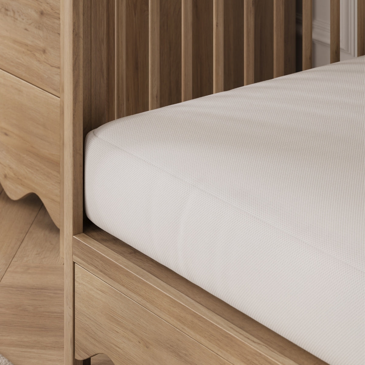 Wooden crib with a white mattress inside