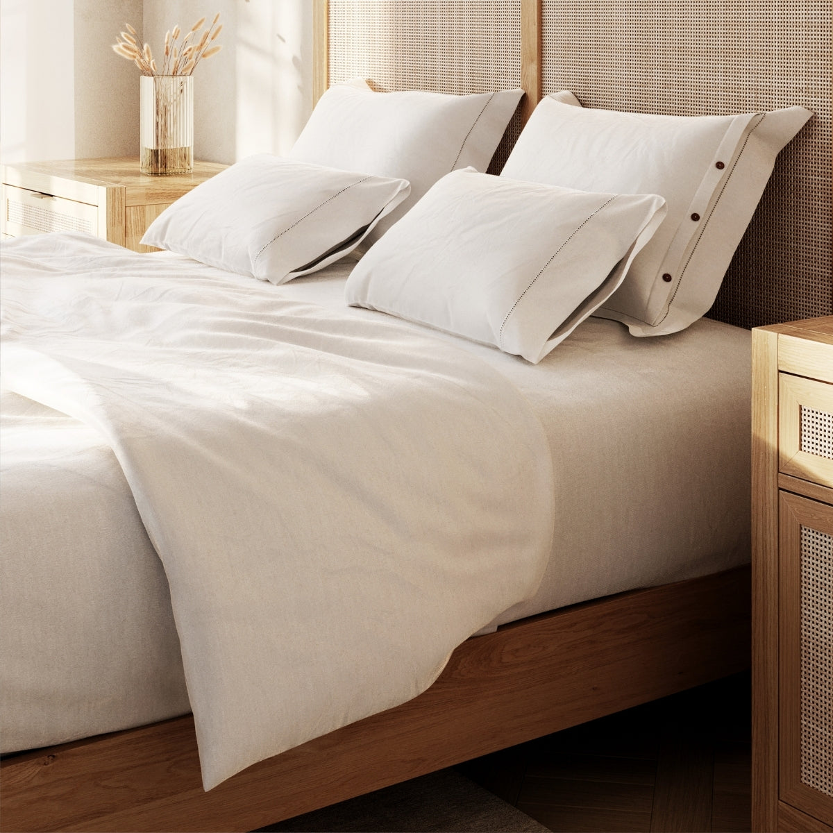 Neatly made bed with white bedding and pillows in a bedroom setting.