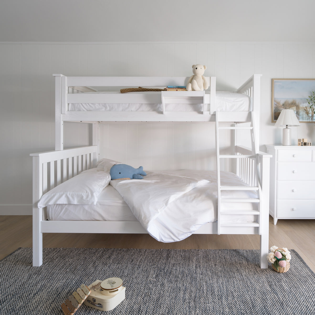 White bunk bed in a room with toys and a dresser. #color_washed white #size_Twin/Full Bunk 