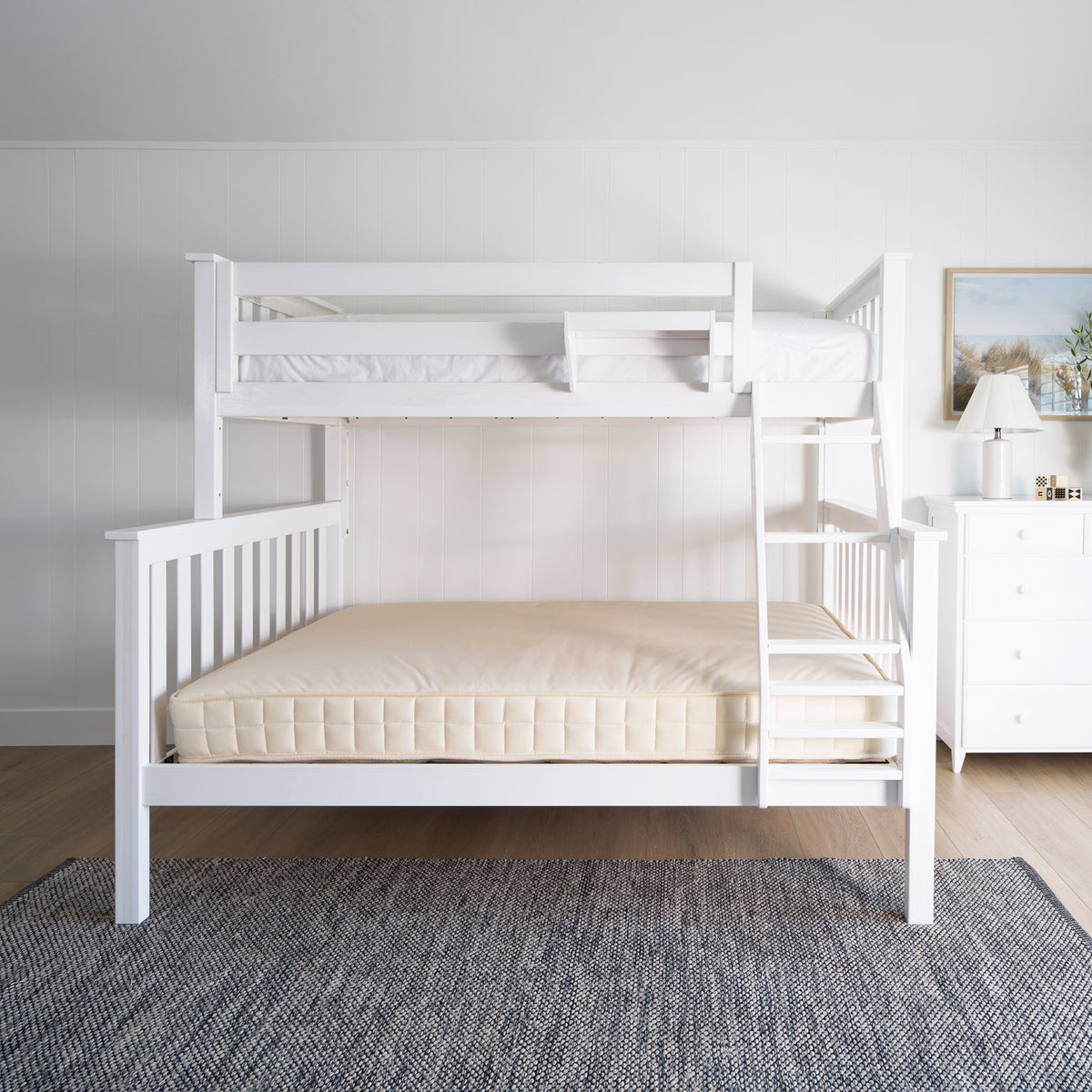 White bunk bed in a room with a gray rug and a dresser. #color_washed white  #size_Twin/Full Bunk 
