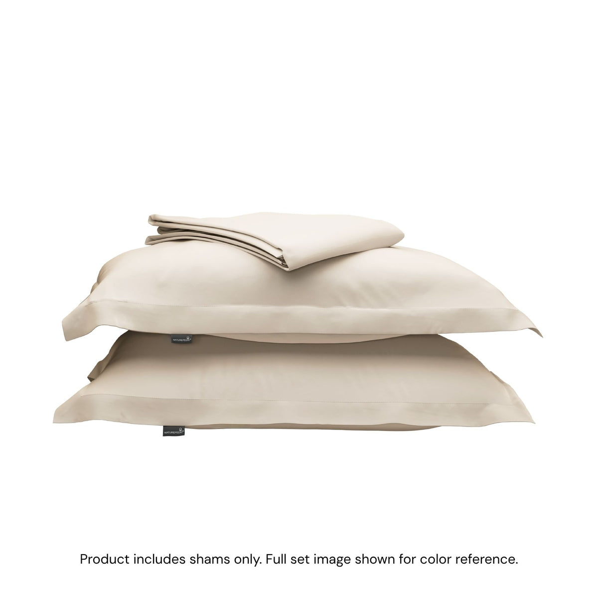 A folded duvet cover on top of two pillow shams. #color_cream