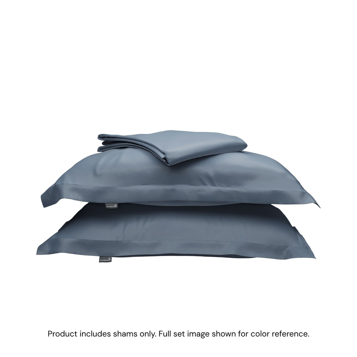 A folded duvet cover on top of two pillow shams. #color_mineral blue